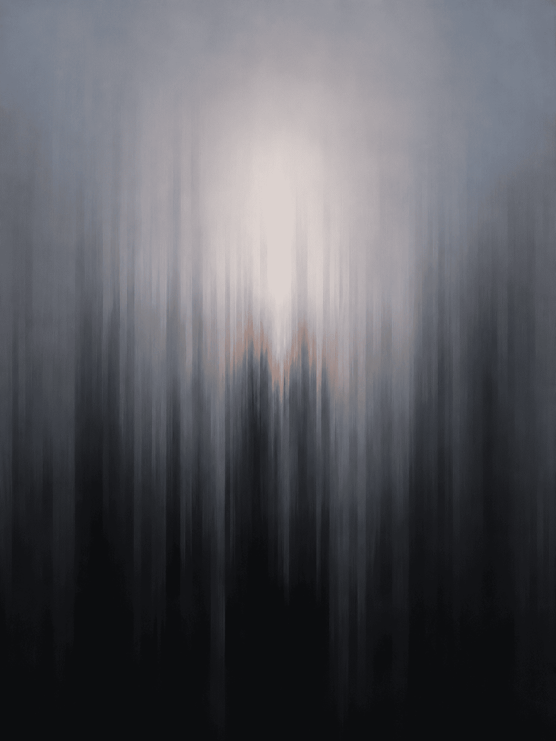 A pale glow behind grey fog, stretched into long vertical streaks that darken toward the bottom