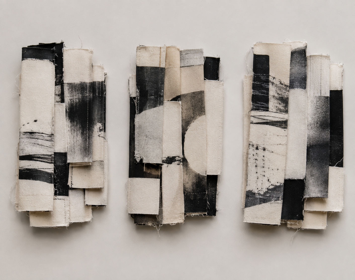 Three sculptural wall works of folded and layered photographic textile in black and white